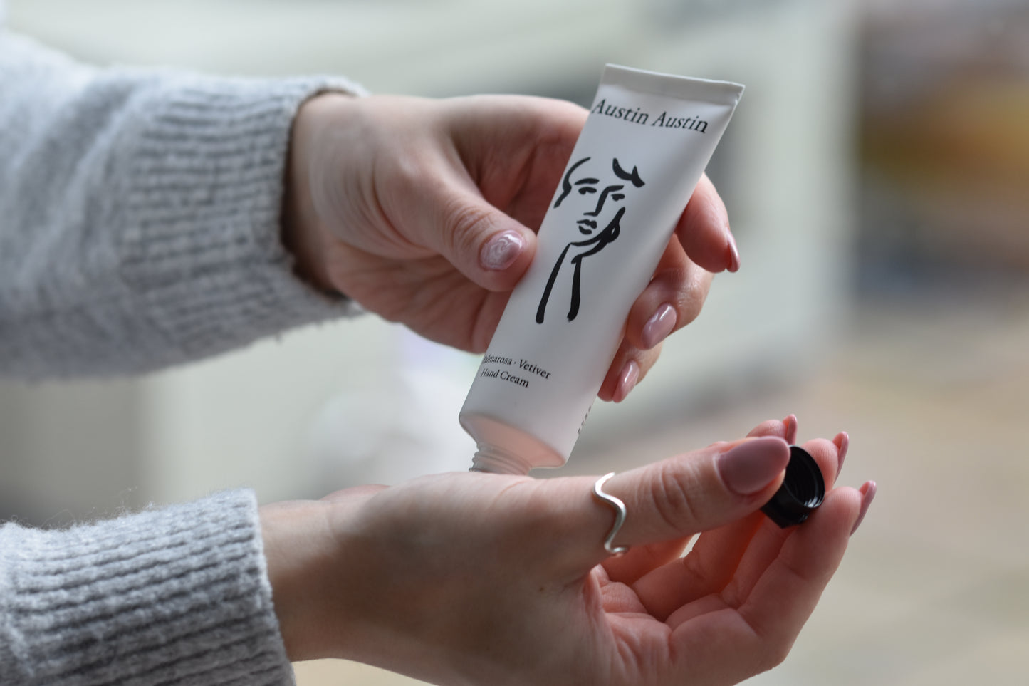 Austin Austin Organic Palmarosa & Vetiver hand cream tube with face outline artwork by Christian Newby.