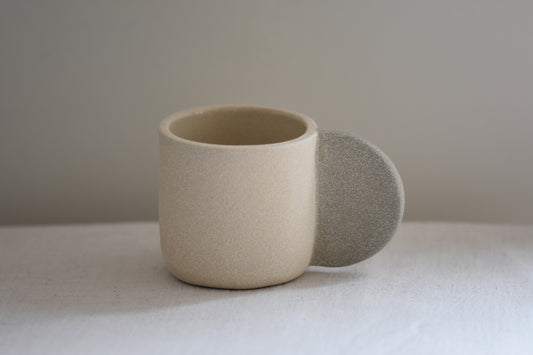 Brutes ceramics stoneware medium signature mug in sand with grey handle and textured finish.