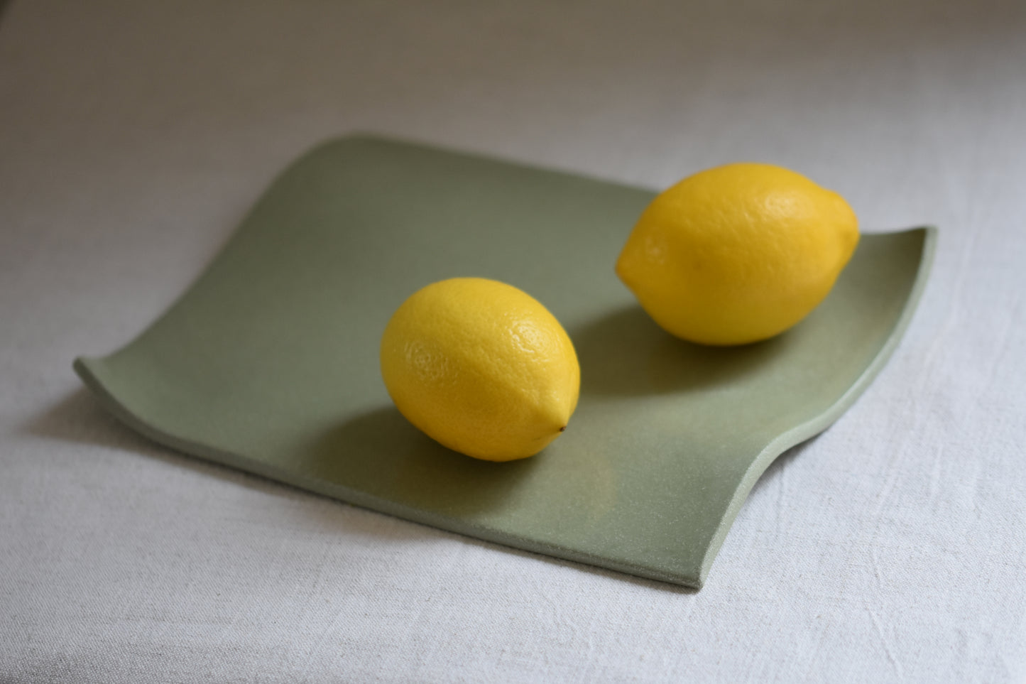 Brutes ceramics medium stoneware rumpled wavy platter in pistachio green with lemons.