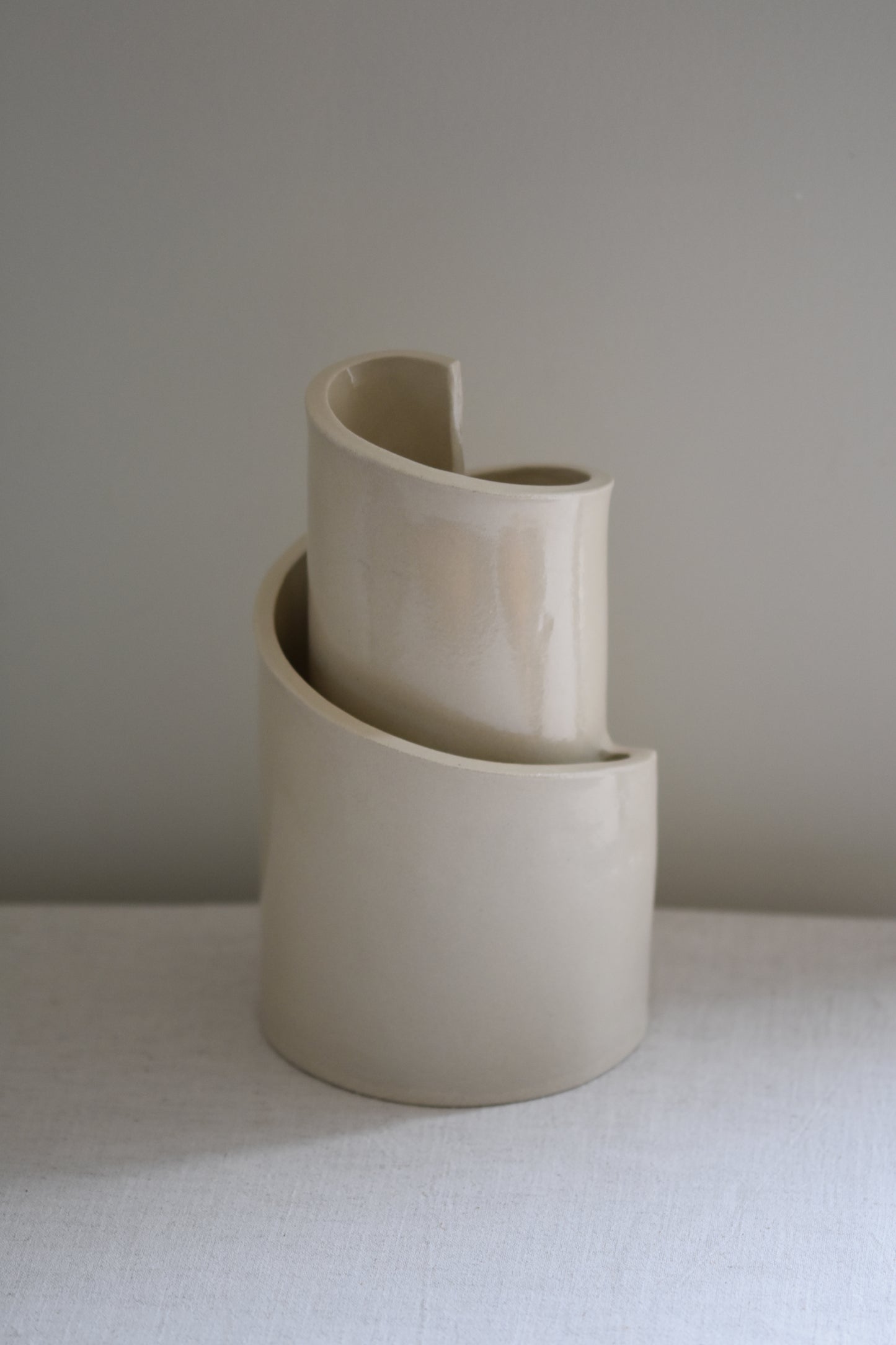 Brutes ceramics cream stoneware vase in a spiral shape with clear glossy finish.