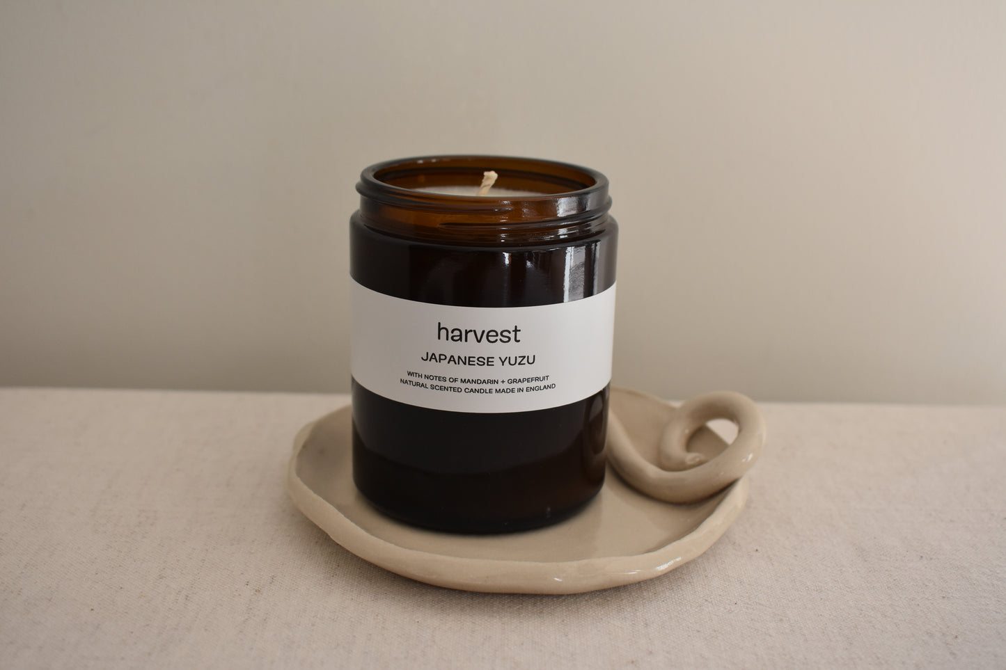 Harvest Japanese Yuzu candle in brown glass vessel on We Are Clay white ceramic  spiral Wee Dish.