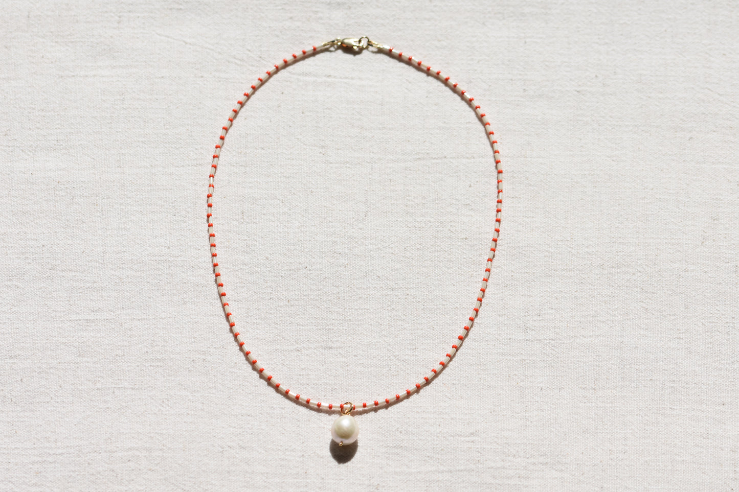 By my hands Little Baroque Necklace with stripey red and white Miyuki and Toho seed beads, small freshwater baroque pearl and gold-filled fastenings.