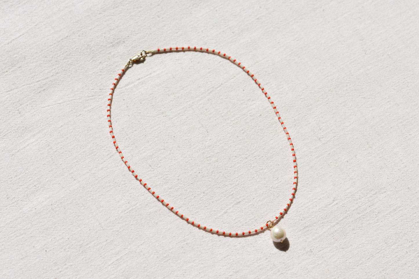 By my hands Little Baroque Necklace with stripey red and white Miyuki and Toho seed beads, small freshwater baroque pearl and gold-filled fastenings.
