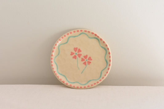 Blume Ceramics white stoneware small plate with hand painted floral design in pink and light green.