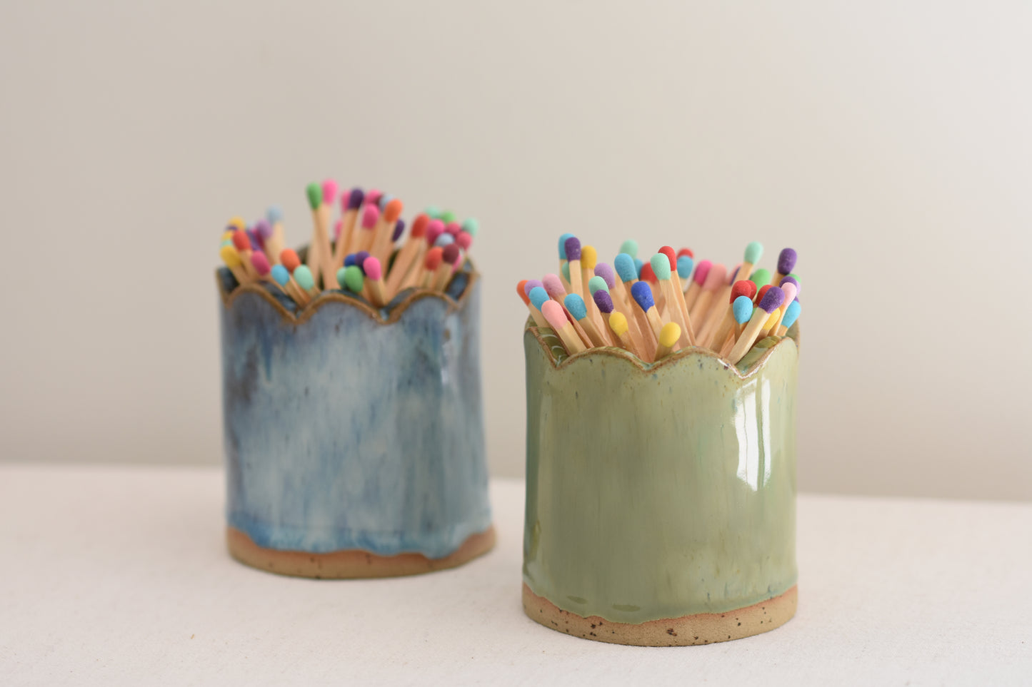 Blume Ceramics stoneware matchstick holders, glazed in green and blue, with scalloped tops and multicolour matches.