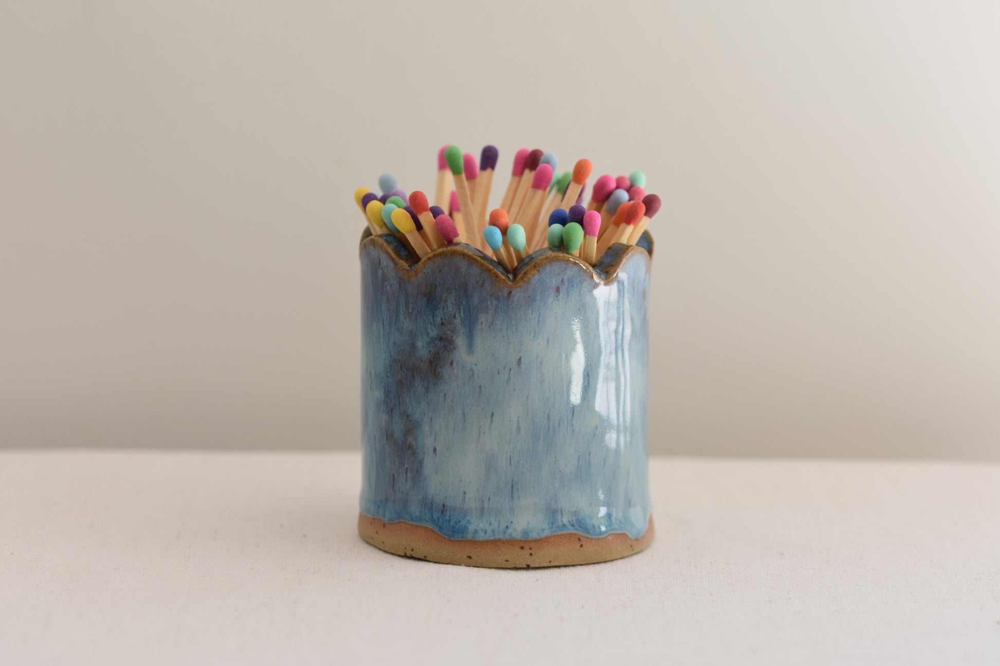Blume Ceramics stoneware matchstick holder, glazed in blue, with scalloped top and multicolour matches.