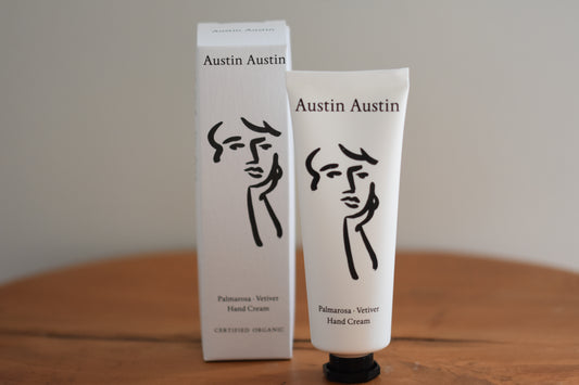 Austin Austin Organic Palmarosa & Vetiver hand cream tube with face outline artwork by Christian Newby on the tube and box.