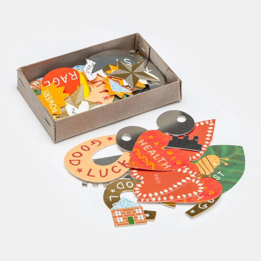 Hadley Paper Goods Manifestation Charms, multicolour card shapes including  hearts, horseshoes and houses, in a grey box on a white background.