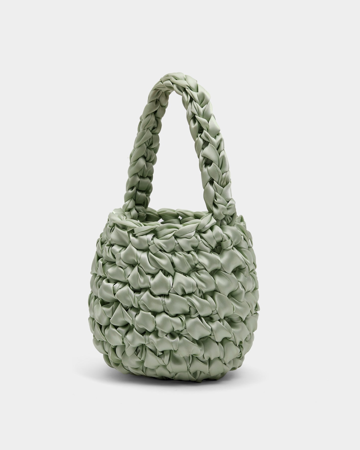 Isla de Gar sage green ribbon crochet bag with handle on a white background.