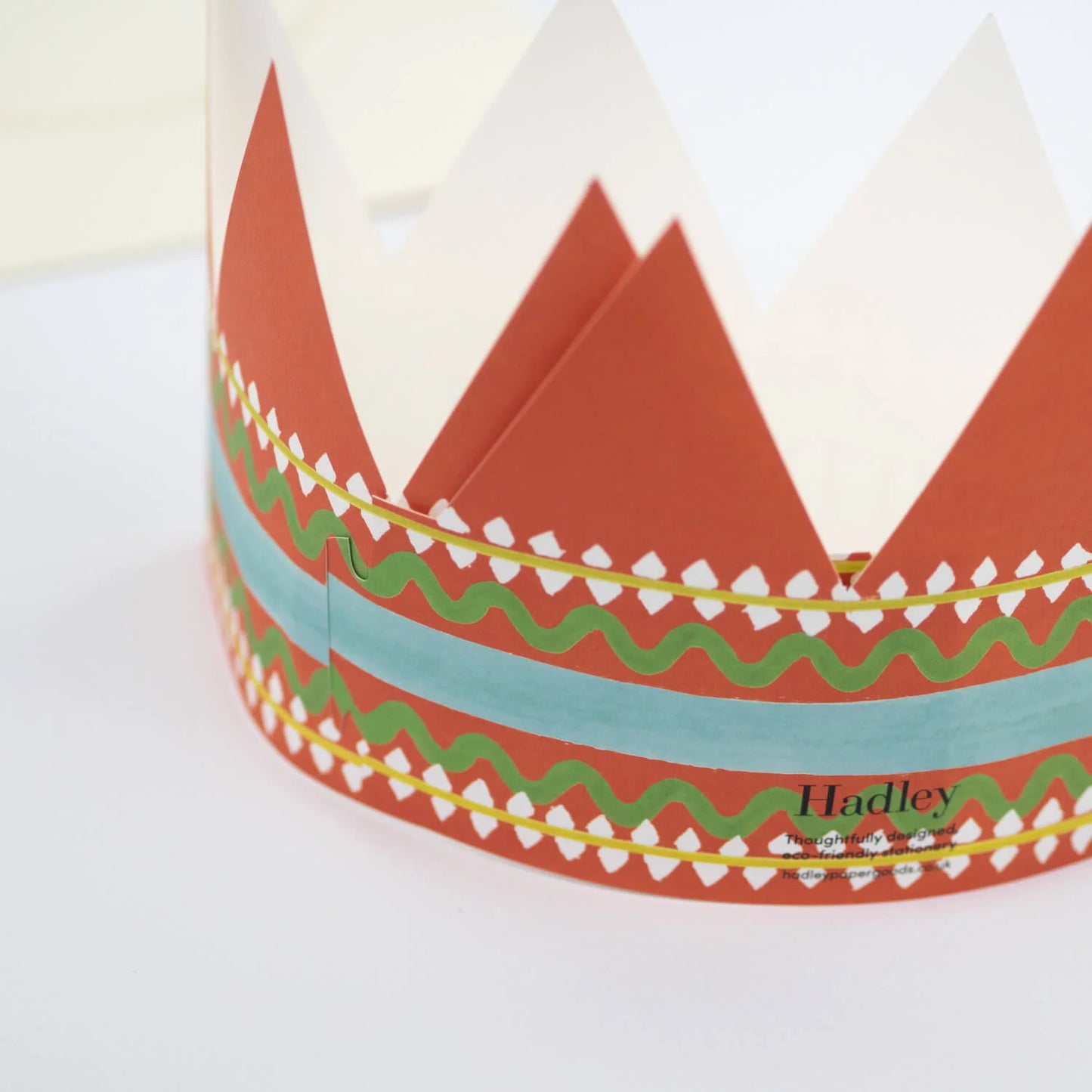 Hadley Paper Goods Birthday King party hat crown shaped card with orange, green and blue pattern, back view, on a white background.