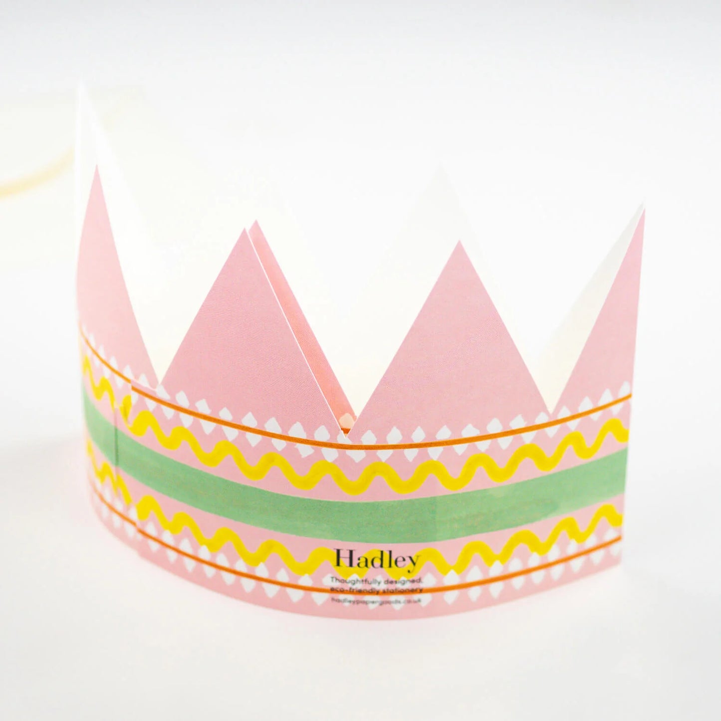 Hadley Paper Goods Birthday Queen party hat crown shaped card with pink, green and yellow pattern, back view, on a white background.
