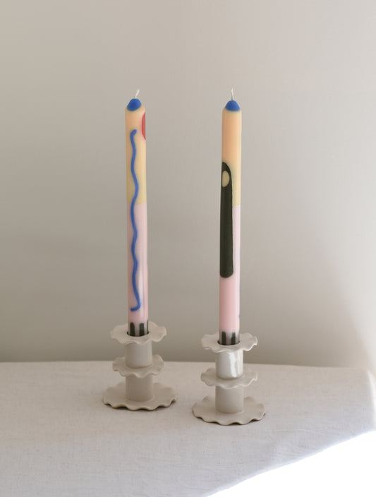 A pair of two Pygmalion London Majorelle dinner candles with Moroccan inspired design in peach and pale pink.