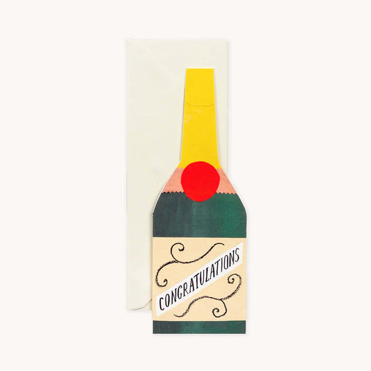 Hadley Paper Goods Congratulations Champagne bottle shaped card in green, red and yellow with an ivory envelope, on a white background.