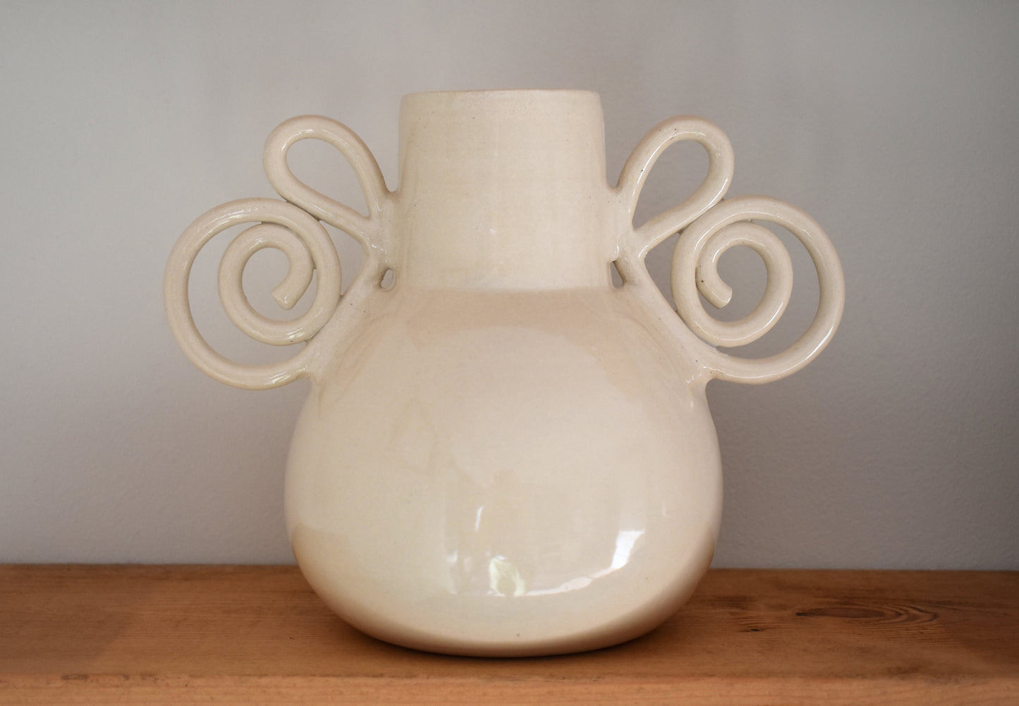 We Are Clay Pretzel Vase in white ceramic with spiral handles.