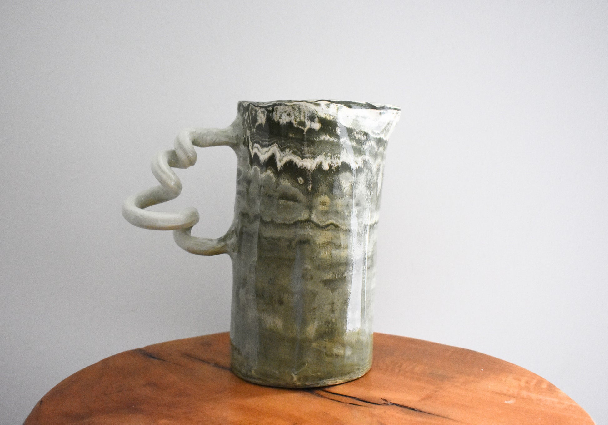 Harlie Brown ceramic Mesmerising Marbles Wiggle Jug in green and white marbled clay with curly handle.