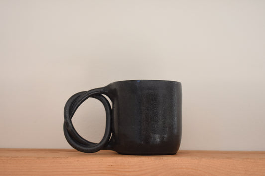 We Are Clay black ceramic Pretzel Mug with twisted pretzel handle.