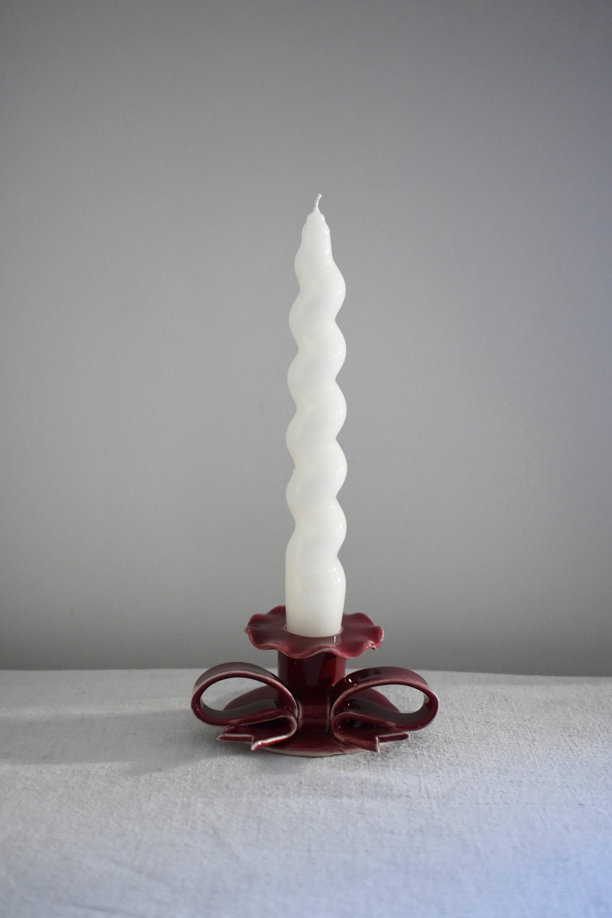 Superfluities stoneware ceramic Bow Candlestick with frill in burgundy.