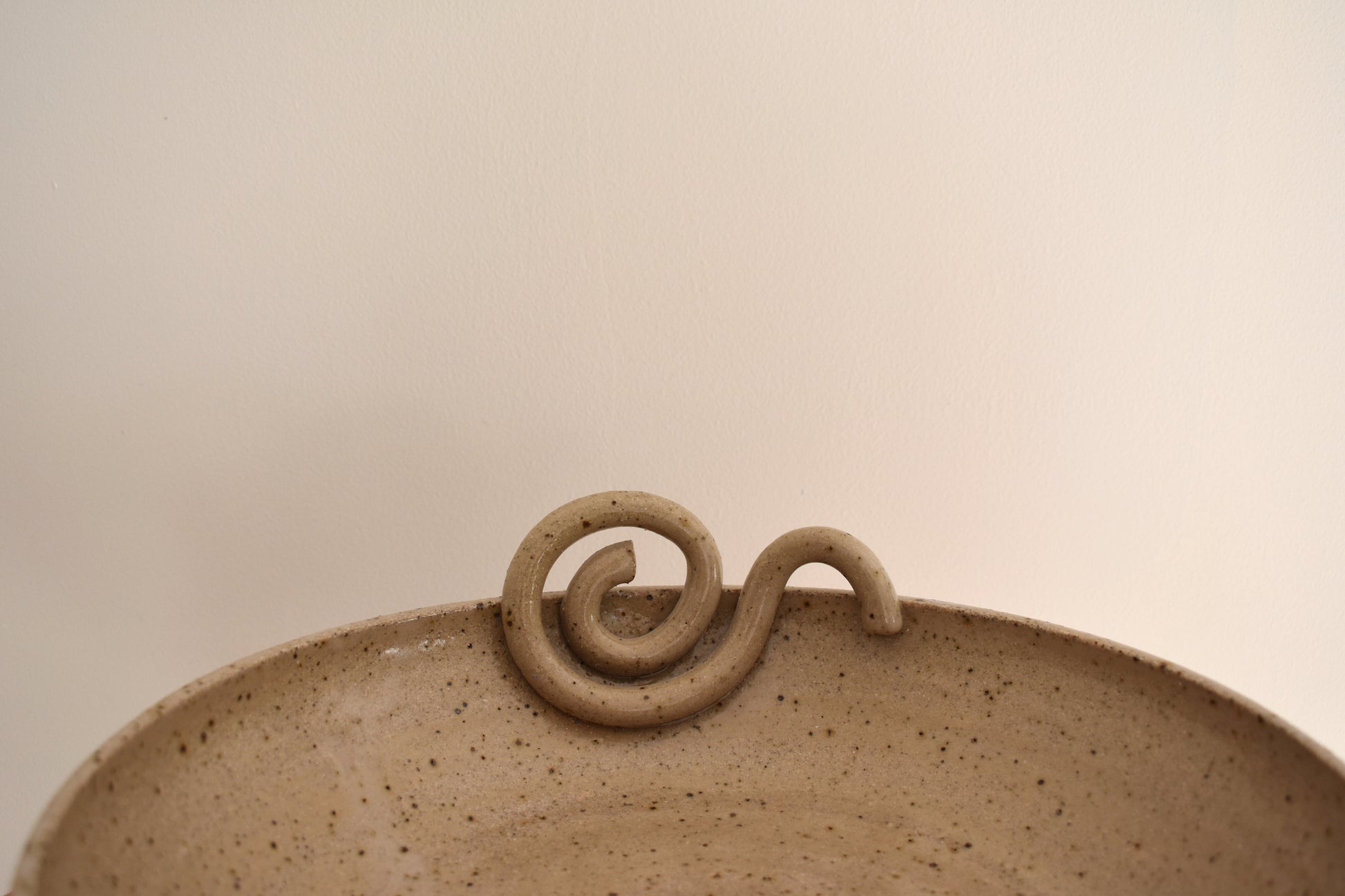 We Are Clay Snail fruit bowl in beige flecked ceramic with spiral design.