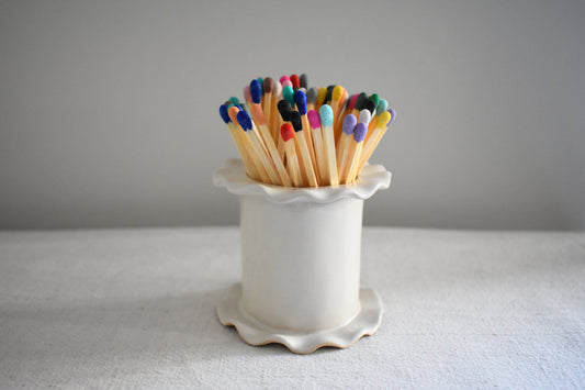 Superfluities stoneware ceramic frilled Matchstick Holder pot in white with multicolour matches.