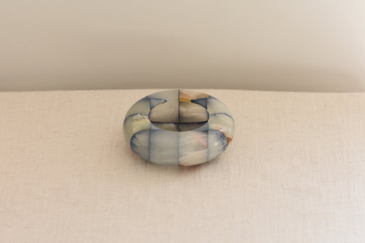 Vintage checkered onyx blue and brown dish on a beige background.