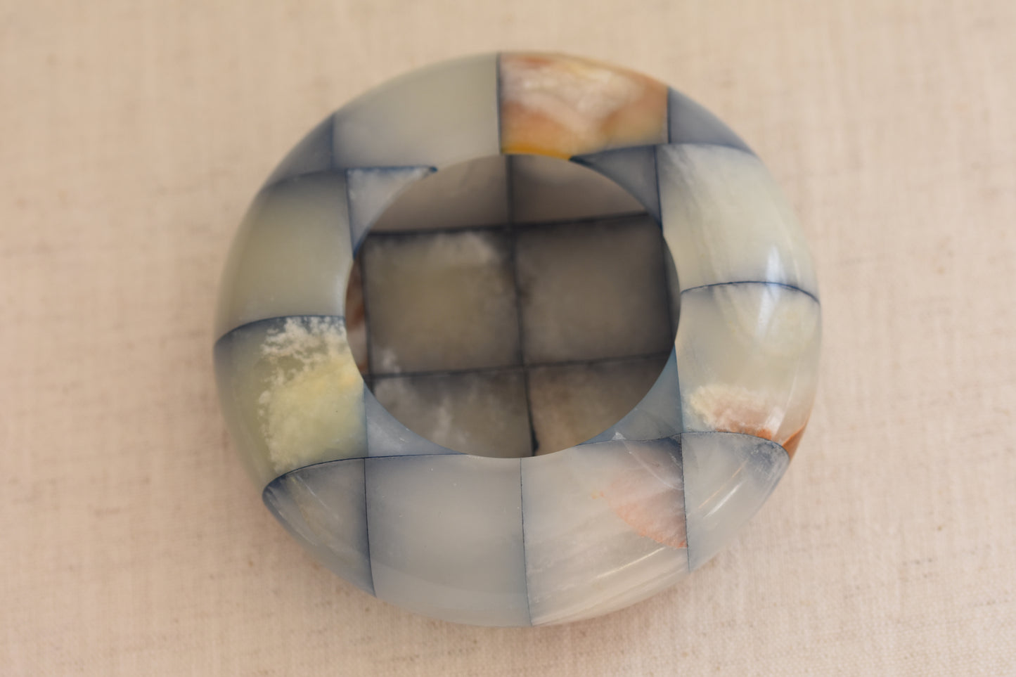 Vintage checkered onyx blue and brown dish on a beige background.