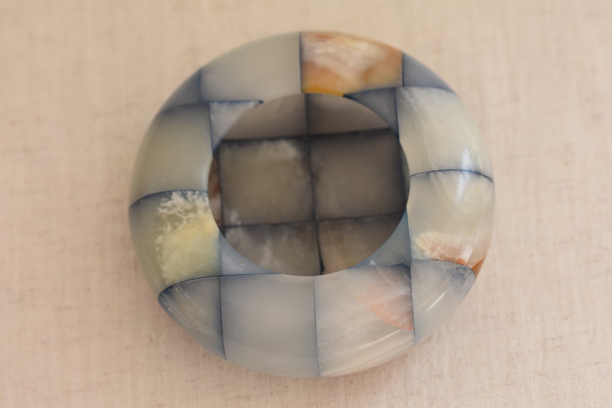 Vintage checkered onyx blue and brown dish on a beige background.