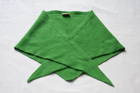Bright green Merino wool triangle scarf by Roake Studio lay flat and crossed over on a beige background.