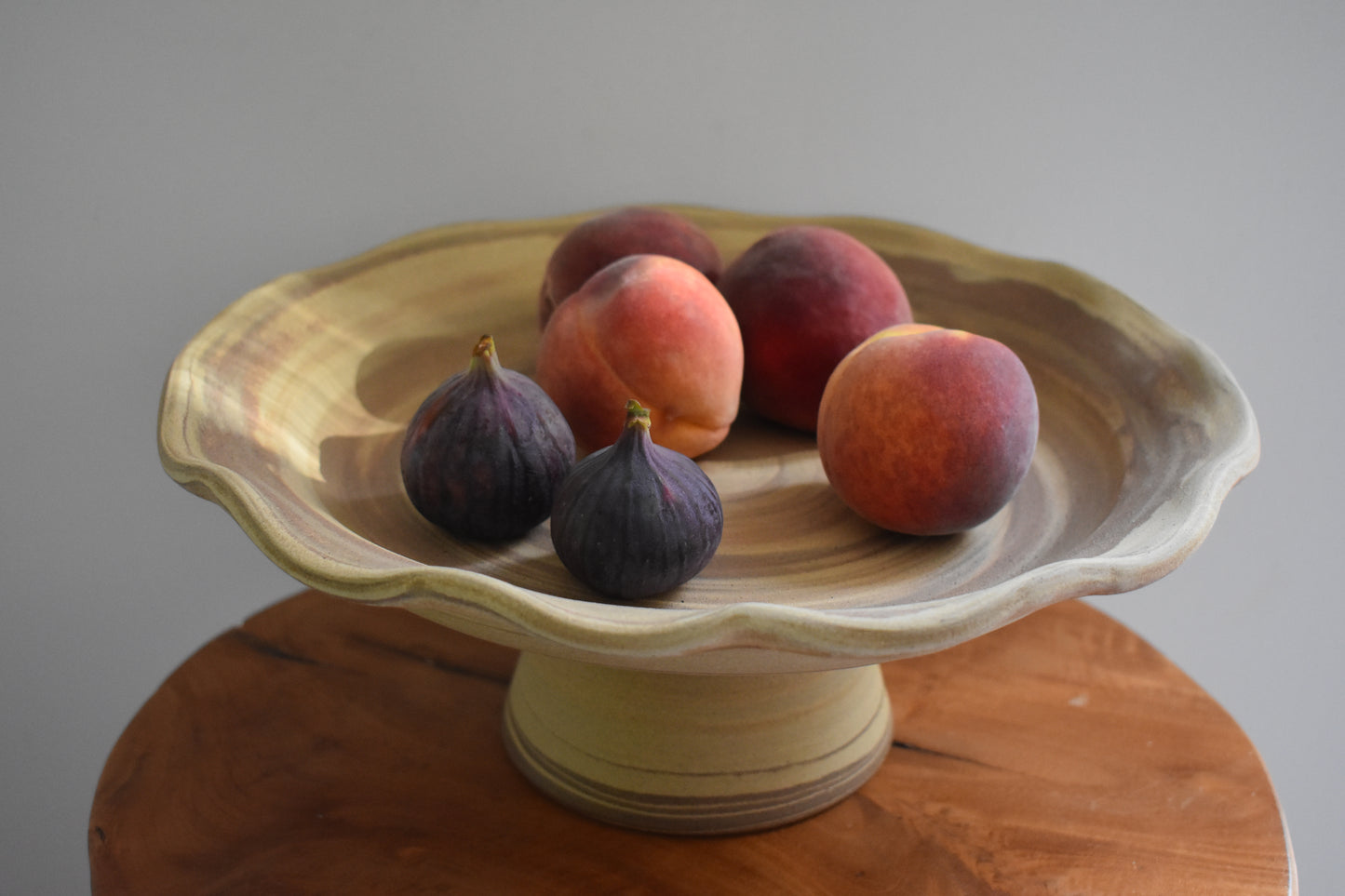 Ceramics by Sunny stoneware wavy frilled edge pedestal fruit bowl with brown and beige marble pattern.