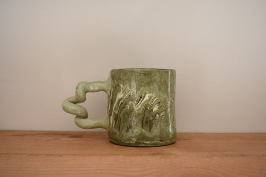 Harlie Brown ceramic Mesmerising Marbles Wiggle Mug in green and white marbled clay with curly handle.