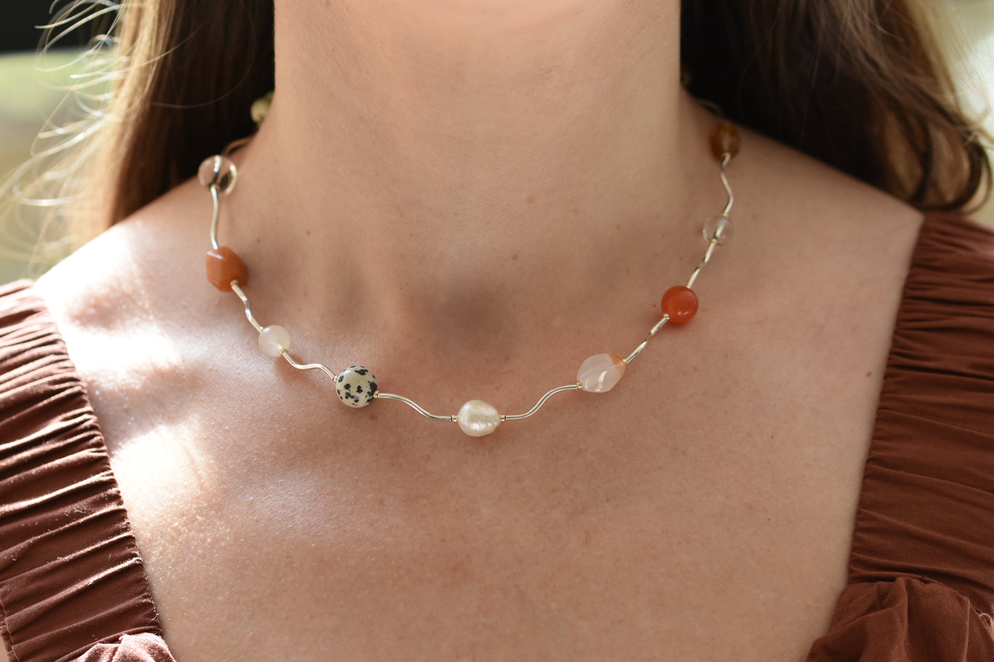 By my hands Sienna Ripple Necklace with wavy sterling silver ripples and oval clasp combined with earthy gemstones including unakite, dalmatian jasper, freshwater pearl, and coloured jade. 