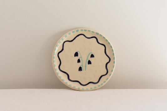 Blume Ceramics white stoneware small plate with hand painted floral design in navy and light green.