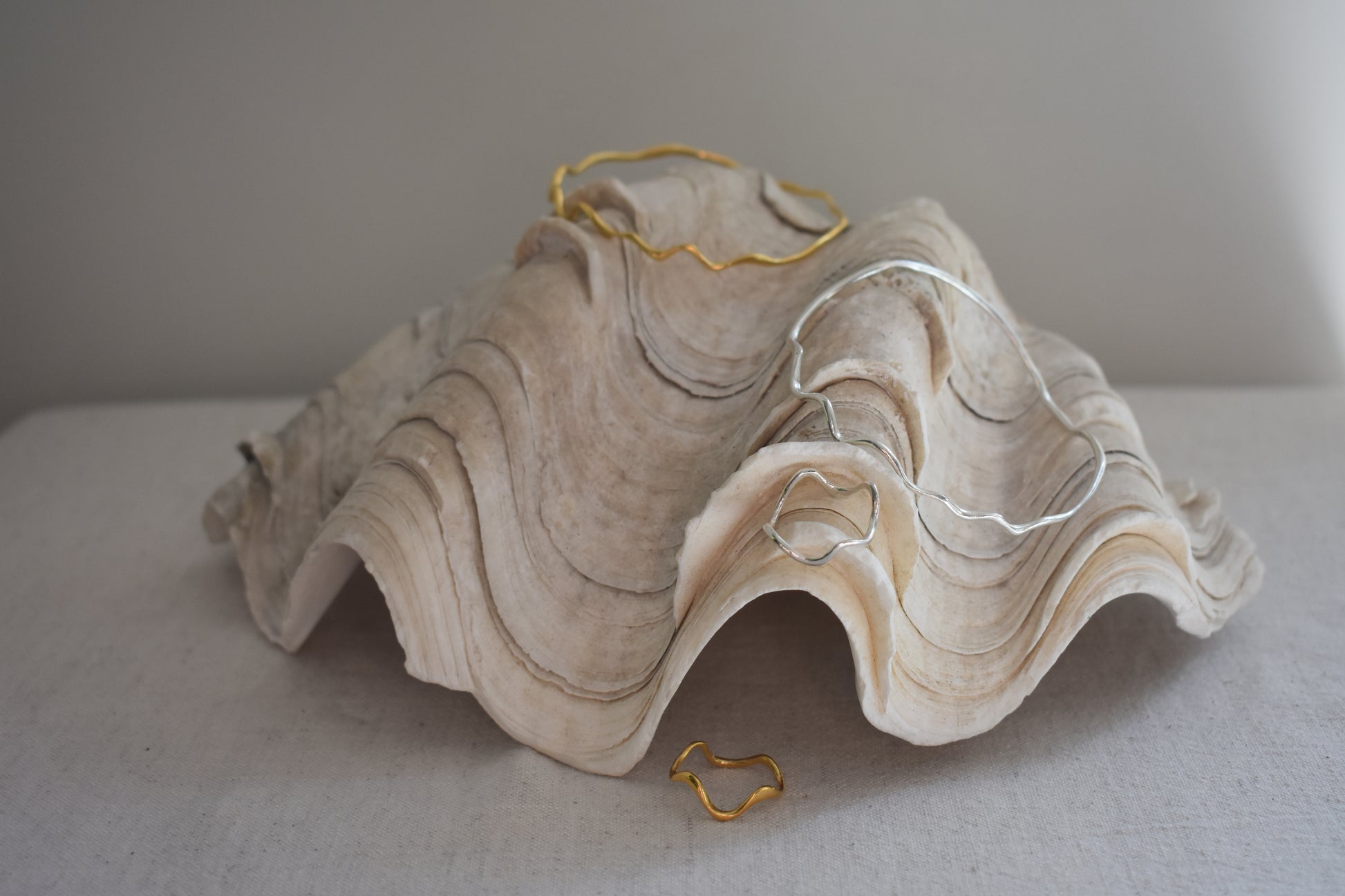 Hannah Bourn Saccostrea wavy rings and bangles in gold and silver.