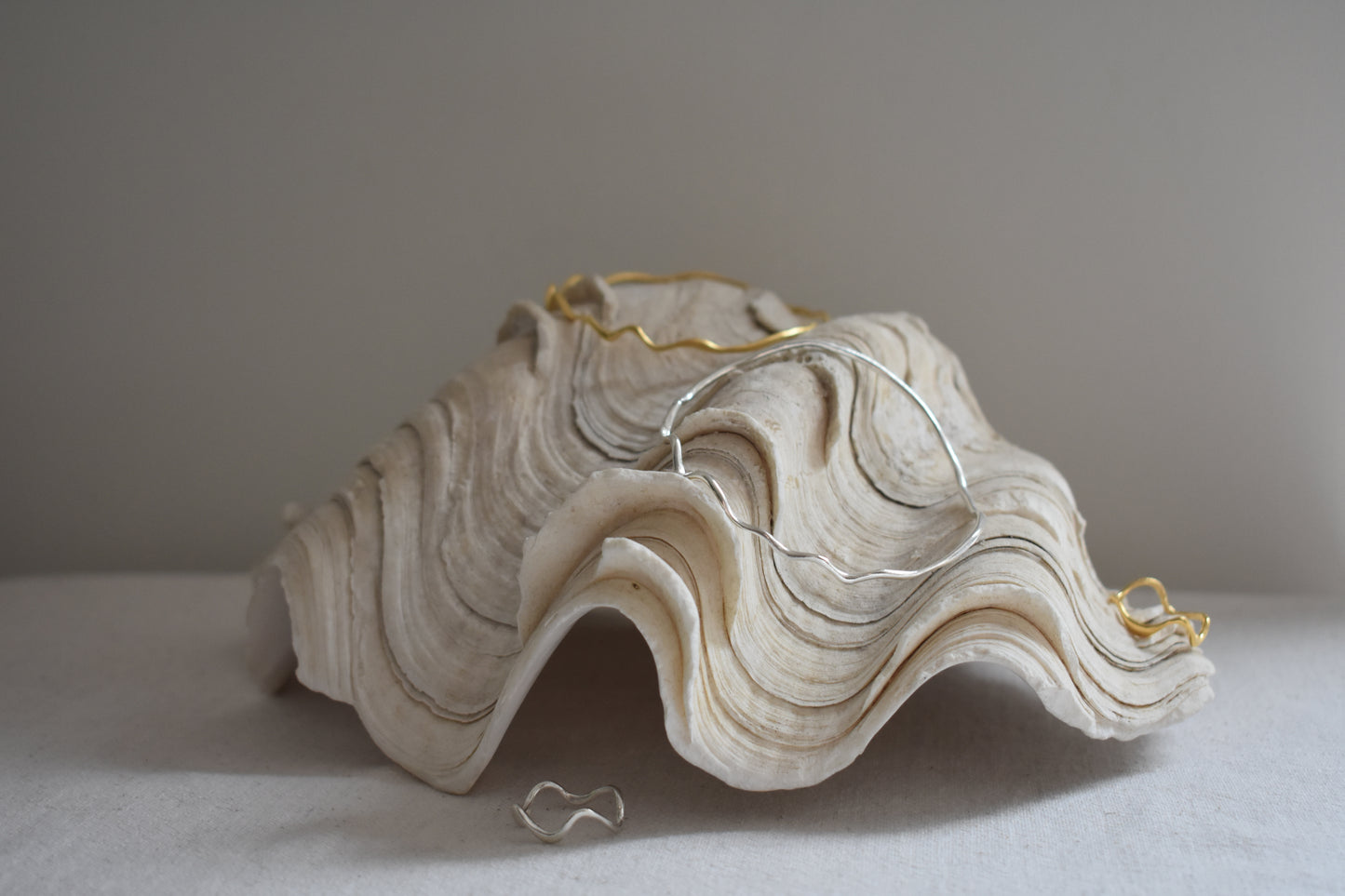 Hannah Bourn Saccostrea wavy rings and bangles in gold and silver.