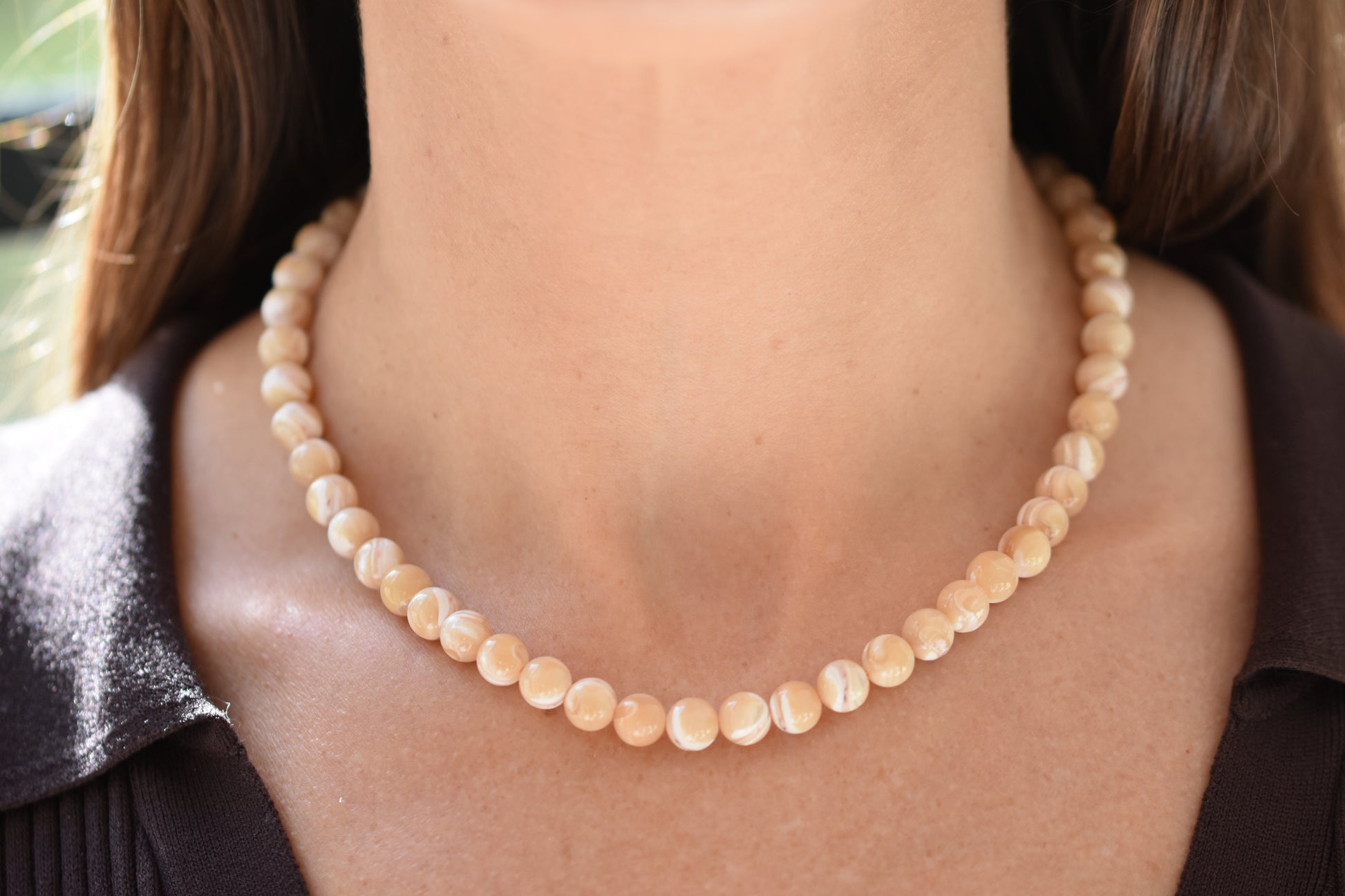 By my hands Sandy Bei Necklace of opalescent light yellow Mother of Pearl beads, shown on a person.