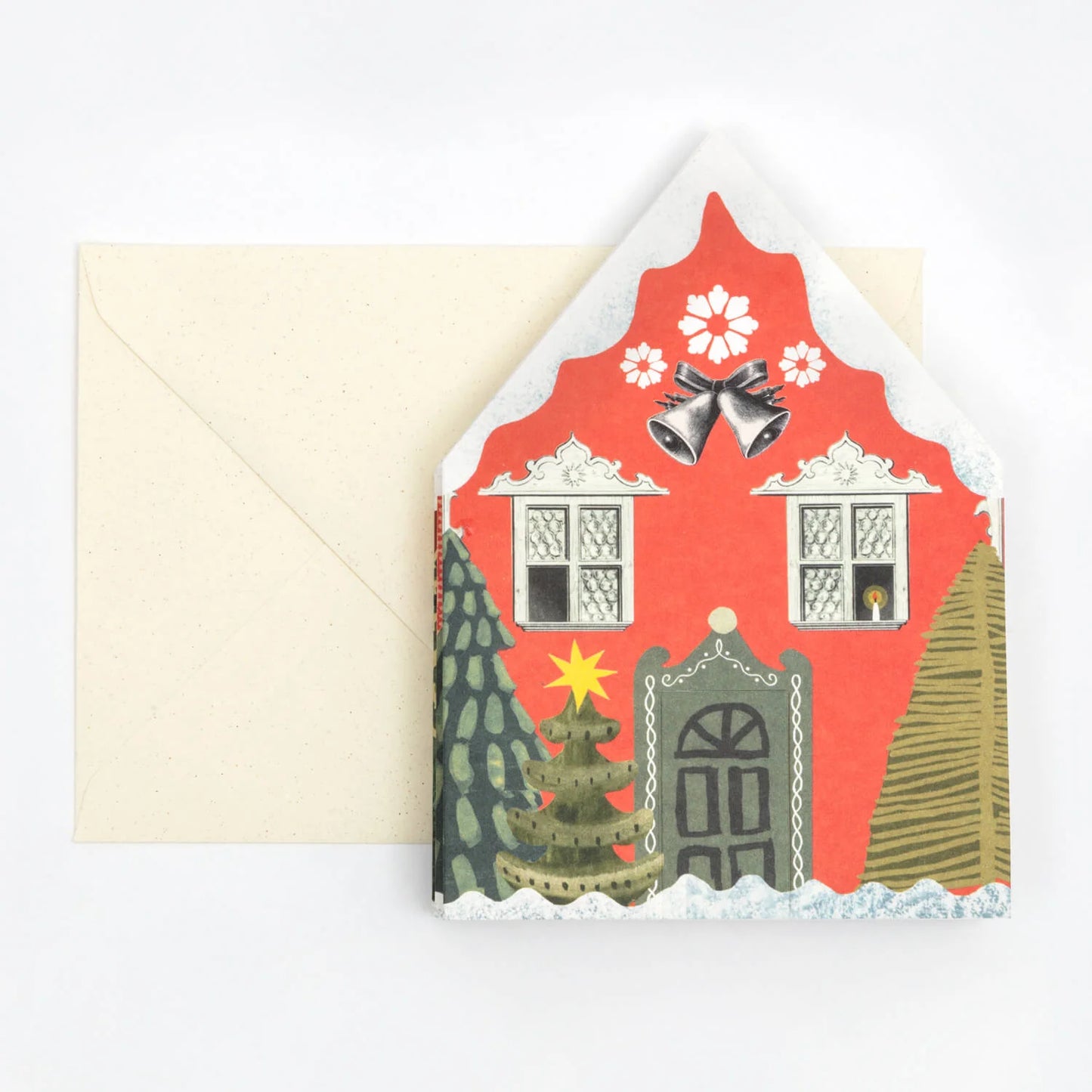 Hadley Paper Goods Concertina Christmas houses card, folded up to show 1 decorative house, in shades of red and green, with an ivory envelope, on a white background.