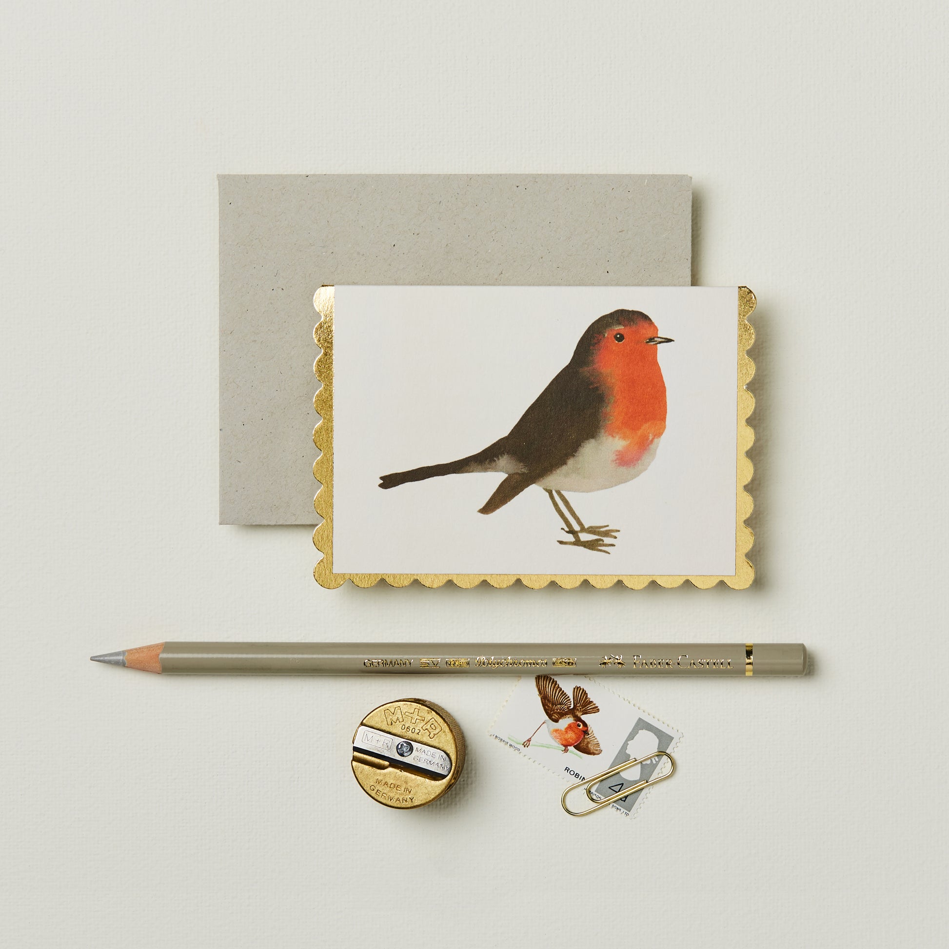 Wanderlust Paper Co. mini robin card with gold scalloped edges, shown next to stationery on a pale grey background.