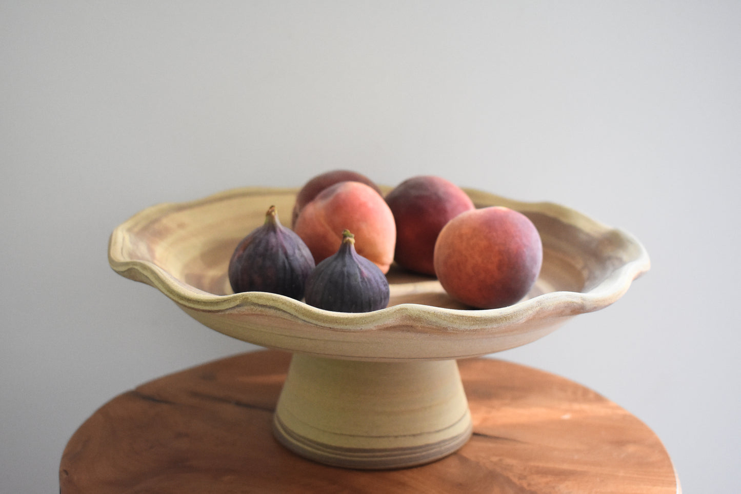 Ceramics by Sunny stoneware wavy frilled edge pedestal fruit bowl with brown and beige marble pattern.