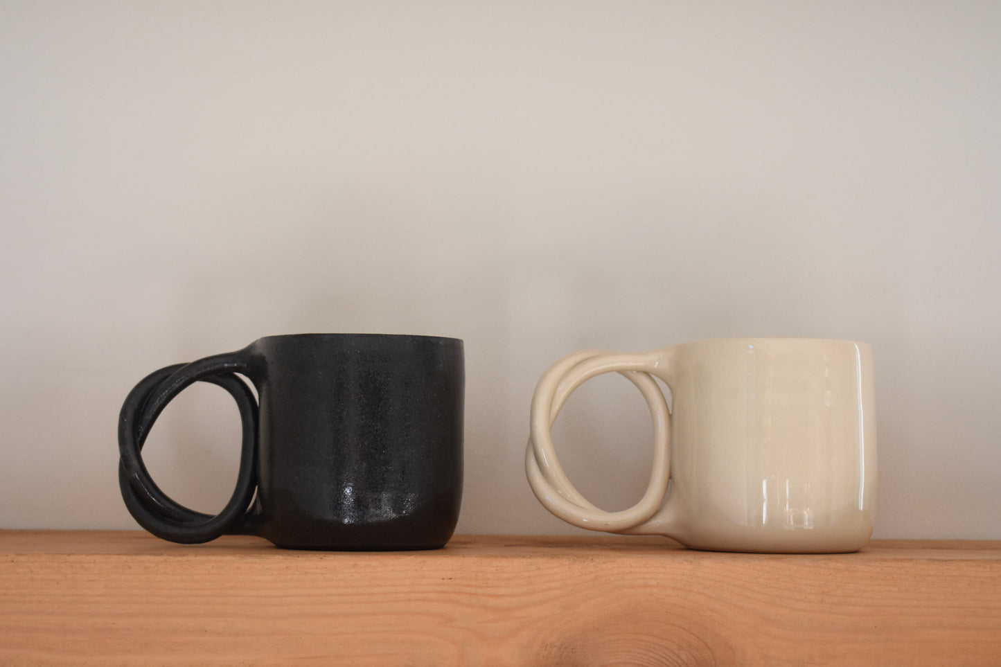 We Are Clay ceramic Pretzel Mugs with twisted pretzel handles in black and white.