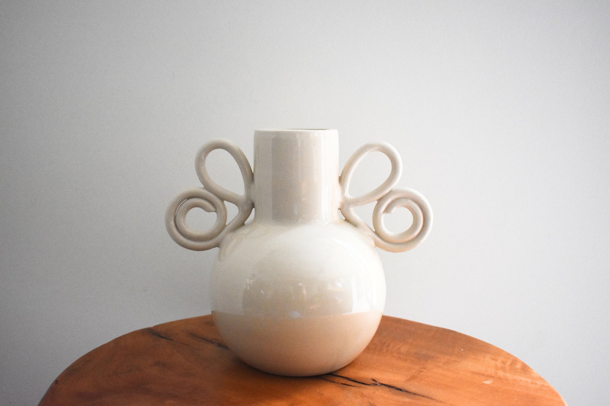 We Are Clay Butterfly Wing Vase in white ceramic with spiral handles.